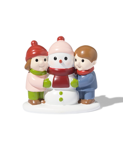 enfants avec bonhomme de neige devant le village de Noël