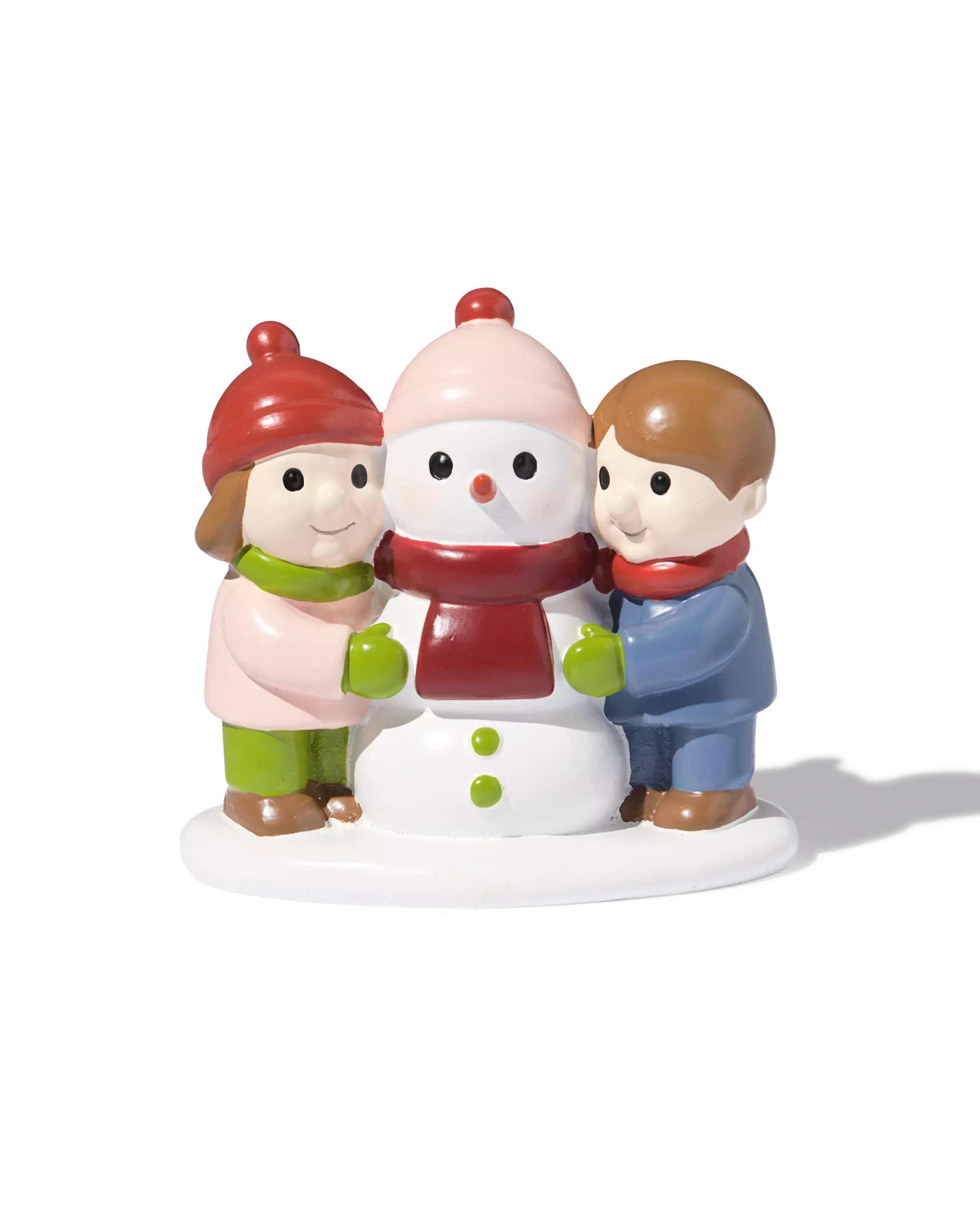 enfants avec bonhomme de neige devant le village de Noël