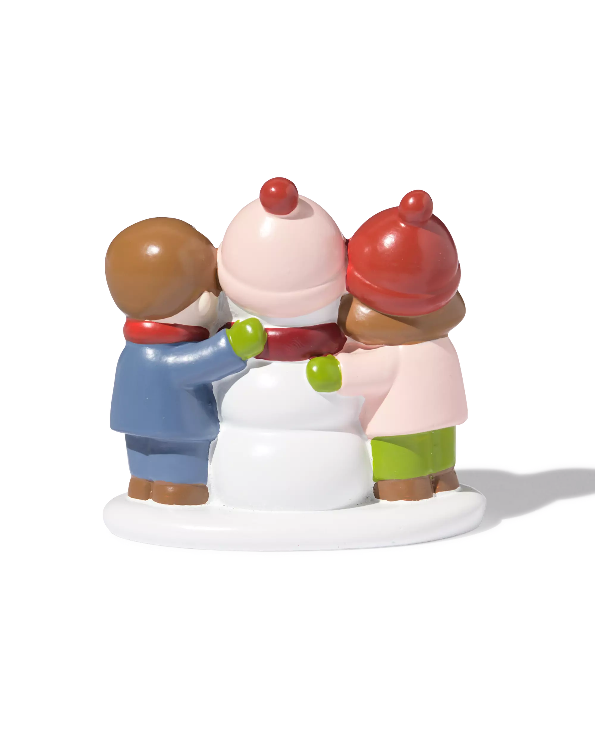 enfants avec bonhomme de neige devant le village de Noël